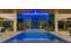 A serene pool and spa with a gentle waterfall, surrounded by lush palm trees and tropical landscaping at 540 S Polk Dr, Sarasota, FL 34236