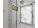 Luxurious shower with marble walls, hexagon tile flooring, glass door, and rainfall shower head for ultimate relaxation at 540 S Polk Dr, Sarasota, FL 34236