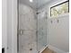 Sleek glass shower with marble-patterned tile and a window offering natural light and outdoor views at 540 S Polk Dr, Sarasota, FL 34236