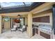 Screened-in lanai featuring a built-in outdoor kitchen with stainless steel grill and beverage cooler at 5624 Aaron Ct, Sarasota, FL 34232