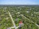 Overhead view shows the home's placement among trees in a lushly vegetated, serene neighborhood setting at 5672 Jonesboro Ave, North Port, FL 34288