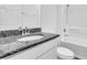 Bathroom showcasing a granite countertop, white cabinets, and a shower-tub combo at 5672 Jonesboro Ave, North Port, FL 34288