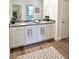 Bright bathroom showcasing double vanity with stone counters and white cabinets at 5672 Jonesboro Ave, North Port, FL 34288
