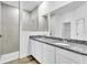Bright bathroom featuring a double sink vanity with granite countertops and a walk-in shower at 5672 Jonesboro Ave, North Port, FL 34288