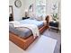 Contemporary bedroom featuring sleek wood platform bed, modern artwork, and minimalist decor at 5672 Jonesboro Ave, North Port, FL 34288