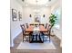 Bright dining room featuring a wooden table, cross-back chairs, a modern light fixture, and hardwood floors at 5672 Jonesboro Ave, North Port, FL 34288