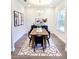 Elegant dining room with a wooden table, black chairs, hardwood floors, and an area rug at 5672 Jonesboro Ave, North Port, FL 34288
