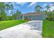 Beautiful one-story home with a long driveway and an attached two-car garage surrounded by lush greenery at 5672 Jonesboro Ave, North Port, FL 34288