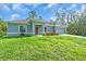 Beautifully landscaped one-story home with a well-manicured lawn, colorful flowers, and an attached two-car garage at 5672 Jonesboro Ave, North Port, FL 34288