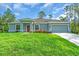 Charming single-story home with a well-manicured lawn, colorful flowers, and an attached two-car garage at 5672 Jonesboro Ave, North Port, FL 34288