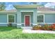 Charming home exterior featuring a inviting entryway and colorful landscaping and two large windows at 5672 Jonesboro Ave, North Port, FL 34288