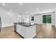 Bright kitchen features an island with a stainless steel sink and views of the backyard through the sliding glass doors at 5672 Jonesboro Ave, North Port, FL 34288