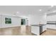 Bright kitchen with island and stainless sink, white walls, and wood flooring at 5672 Jonesboro Ave, North Port, FL 34288