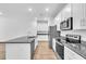 Bright kitchen features stainless steel appliances, granite countertops, white cabinets, and a kitchen island with a sink at 5672 Jonesboro Ave, North Port, FL 34288