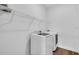 Laundry room with a full-size washer and dryer, storage shelves, and light-colored wood-look flooring at 5672 Jonesboro Ave, North Port, FL 34288
