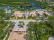 Aerial view of community amenities, including a pool, tennis courts, clubhouse, and security gate at 5821 Valente Pl, Sarasota, FL 34238