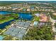 Aerial view of a community with lakes, tennis courts, and swimming pool at 5821 Valente Pl, Sarasota, FL 34238