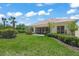 Landscaped backyard with green lawn, mature trees, and a screened lanai at 5821 Valente Pl, Sarasota, FL 34238