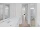Bright bathroom with dual sinks, white cabinetry, and a glass-enclosed shower at 5821 Valente Pl, Sarasota, FL 34238
