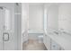 Clean, bright bathroom with a glass-enclosed shower, bath, and tile flooring at 5821 Valente Pl, Sarasota, FL 34238
