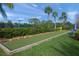 Enjoy the outdoors with this bocce ball court with manicured landscaping and mature palm trees in the background at 5821 Valente Pl, Sarasota, FL 34238