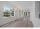 Sun-filled dining room with wood floors, white walls, and elegant chandelier at 5821 Valente Pl, Sarasota, FL 34238
