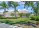 Charming one-story home featuring a well-manicured lawn, lush landscaping, and a welcoming entrance at 5821 Valente Pl, Sarasota, FL 34238