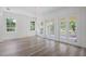 Bright, sun-filled living room featuring hardwood floors, large windows and doors to outside at 5821 Valente Pl, Sarasota, FL 34238