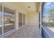 Tiled and screened patio featuring access through sliding glass doors at 5821 Valente Pl, Sarasota, FL 34238