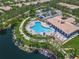 Aerial view of a community pool with ample seating and a clubhouse overlooking the water at 5821 Valente Pl, Sarasota, FL 34238