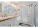 Well-lit bathroom with double sinks, wood countertop, and direct access to the backyard at 601 Gulf S Dr, Bradenton Beach, FL 34217