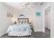 Coastal bedroom with nautical decor, ceiling fan, and gray wood-look tile flooring at 601 Gulf S Dr, Bradenton Beach, FL 34217