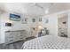 Bright bedroom features light grey wood floors, TV, dresser, and ensuite bathroom at 601 Gulf S Dr, Bradenton Beach, FL 34217