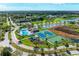 Aerial view of community amenities including pool, tennis courts, playground and lake, nestled within lush landscaping at 6106 New Paris Way, Ellenton, FL 34222