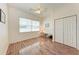 Bright bedroom featuring wood-look floors, ceiling fan, large window and closet at 6106 New Paris Way, Ellenton, FL 34222
