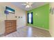 Bedroom featuring wood-look floors, bright green accent wall, and dresser at 6106 New Paris Way, Ellenton, FL 34222