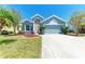 Charming home featuring a well manicured lawn with a colorful array of flowers and mature trees at 6106 New Paris Way, Ellenton, FL 34222