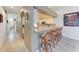 Hallway view of kitchen bar seating area with bar stools, white cabinets, and granite counters at 6106 New Paris Way, Ellenton, FL 34222