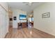 Open-plan living room with wood floors, entertainment center, and access to other rooms at 6106 New Paris Way, Ellenton, FL 34222