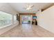 Living room with tile flooring, ceiling fan, arched window, and sliding glass doors to the lanai at 6106 New Paris Way, Ellenton, FL 34222