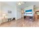Cozy living room featuring wood-look floors, ceiling fan, and entertainment center at 6106 New Paris Way, Ellenton, FL 34222