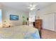 Bedroom featuring wood-look floors, ceiling fan, and ensuite bathroom at 6106 New Paris Way, Ellenton, FL 34222