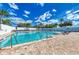 Community pool with lounge chairs and a beautiful blue sky, perfect for relaxation and socializing at 6106 New Paris Way, Ellenton, FL 34222