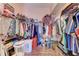 Walk-in closet is filled with an assortment of clothes and storage at 6106 New Paris Way, Ellenton, FL 34222