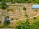 Aerial view of a large lot with a house and a long curved storage building, surrounded by vibrant greenery and access roads at 6321 279Th E St, Myakka City, FL 34251