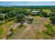 Wide aerial view featuring a home and barn on a large lot with mature landscaping and foliage at 6321 279Th E St, Myakka City, FL 34251
