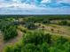 Scenic aerial perspective of an estate featuring rolling green landscape, mature trees, and a pristine residence at 6321 279Th E St, Myakka City, FL 34251