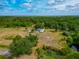 Scenic aerial shot of a property showcasing lush surroundings and an inviting residence with a distinctive roof at 6321 279Th E St, Myakka City, FL 34251