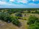 Aerial shot showcasing a home with mature trees on a spacious lot under a partly cloudy sky at 6321 279Th E St, Myakka City, FL 34251
