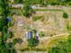 Aerial view displays a tranquil pond near a house, set in a lush green lot and vibrant greenery and access roads at 6321 279Th E St, Myakka City, FL 34251